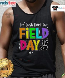 Teacher wearing 'Good, I'm Just Here for Field Day' tank top, enjoying a sunny outdoor school event.