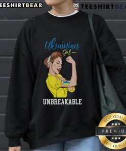 Ukrainian girl in a messy bun wearing a Ukraine sweatshirt, proudly displaying the Ukrainian flag.