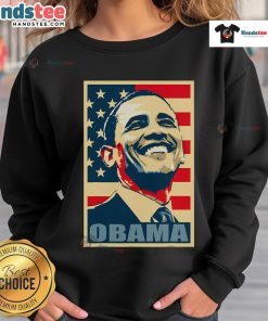 Happy Barack Obama wearing a 44th President sweatshirt with an American flag, representing his Democratic legacy.