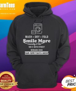 Happy Roman Atwood wearing a 'Smile More' hoodie while doing laundry in Newark, Ohio, showcasing his fun personality.