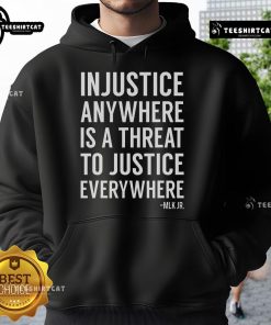 Alt Text: Proud activist wearing a 'Injustice Anywhere is a Threat to Justice Everywhere' hoodie showcasing social justice support.