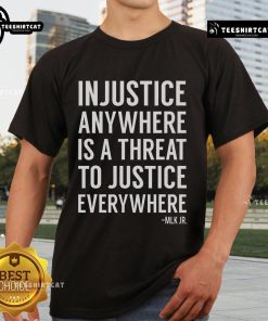 Alt Text: Proud activist wearing 'Injustice Anywhere Is A Threat To Justice Everywhere' t-shirt, showcasing social justice message.