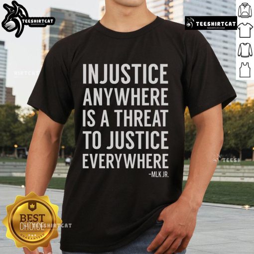 Alt Text: Proud activist wearing 'Injustice Anywhere Is A Threat To Justice Everywhere' t-shirt, showcasing social justice message.