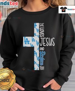 Cozy sweatshirt featuring 'She Loves Jesus and Los Angeles Dodgers Too' design, perfect for fans of faith and baseball.