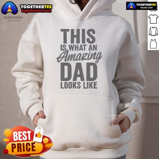A proud dad wearing a 'Nice, This Is What An Amazing Dad Looks Like' hoodie, smiling with his kids in a park.