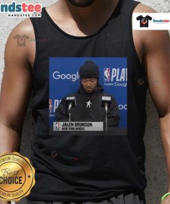 Jalen Brunson at an official press conference wearing a stylish tank top, showcasing his signature style and charisma.