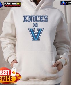 Alt Text: A stylish fan wearing a New York Knicks V hoodie, showcasing team spirit and vibrant colors at a game.