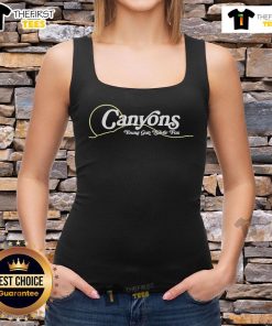 Pretty young woman wearing a silver fox canyons tank top, enjoying the outdoors in a scenic natural setting.