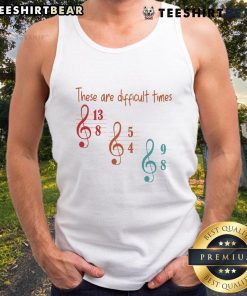 Musician wearing a stylish tank top with 'Top These Are Difficult Times' graphic, showcasing artistic expression and fashion.