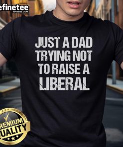 Official Just A Dad Trying Not To Raise A Liberal Premium T-Shirt in black, featuring bold white text for dads.