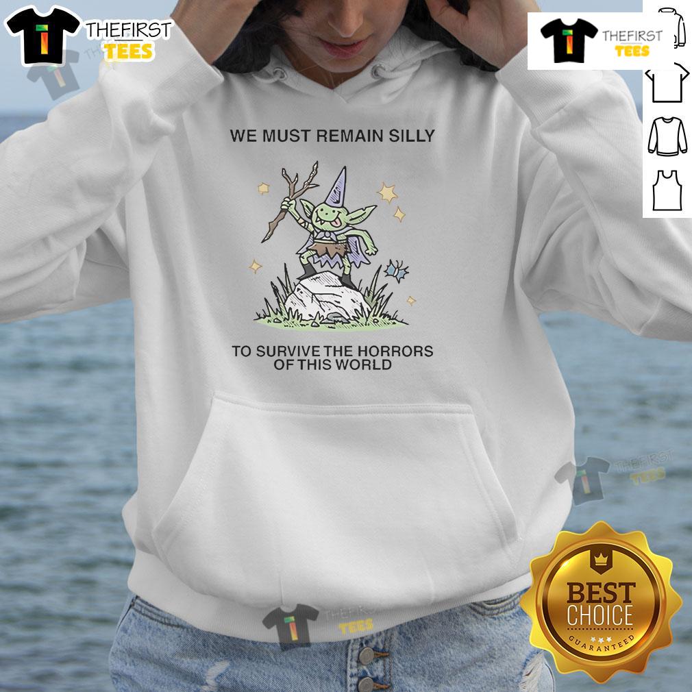Cute We Must Remain Silly To Survive The Horrors Of This World Hoodie Cozy hoodie with 'We Must Remain Silly' slogan, perfect for staying cheerful amidst life's challenges. Cute and comfy design.