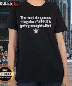 Funny ladies tee featuring the phrase 'The Most Dangerous Thing About Weed Is Getting Caught With It' in vibrant colors.
