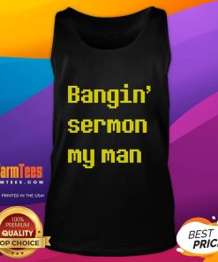 Alt Text: Man wearing a Good Bangin' Sermon tank top, showcasing a casual street style in a vibrant urban setting.