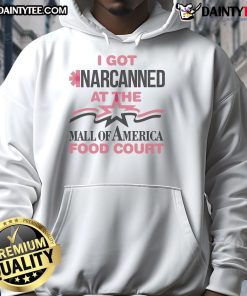 Person wearing 'Good I Got Narcanned at the Mall Food Court' hoodie, showcasing humor and style in a vibrant food court.