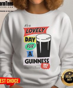 Cozy 'Good It's a Lovely Day for a Guinness' sweatshirt displayed on a wooden background, perfect for beer lovers.