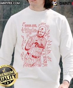 Alt Text: Kyle Schwarber wearing a Philadelphia Phillies sweatshirt, celebrating a good job during a baseball game.