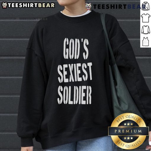 Lizzo wearing 'God's Sexiest Soldier' sweatshirt, showcasing bold style and confidence in a vibrant setting.
