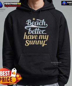 Person wearing a sunny hoodie at a pretty beach, enjoying the warm weather and vibrant ocean views.