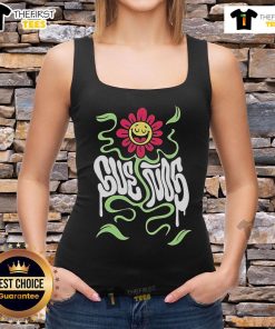 Happy festival-goer wearing a 'Pretty Suenos Music Festival' tank top, smiling amidst vibrant festival atmosphere.