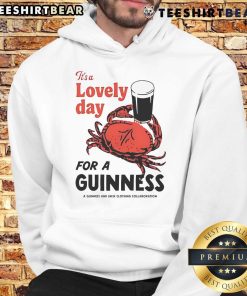 Person wearing a 'Top Crab It's A Lovely Day For A Guinness' hoodie, enjoying a sunny day at the beach.