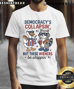 Fourth of July shirt featuring a duck and raccoon with text 'Democracy's Collapsing But These Wieners Be Slapping.'