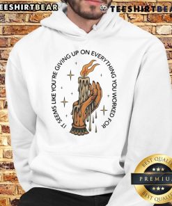 Person in a hoodie holding a candle, symbolizing hope and perseverance, with the phrase 'Top It Seems Like You're Giving Up.'