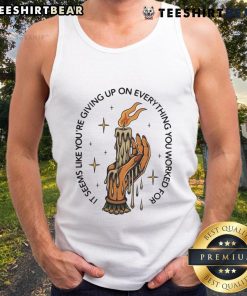 Alt Text: Candle in hand, woman in a tank top looks contemplative, embodying the phrase 'Seems like youre giving up'.