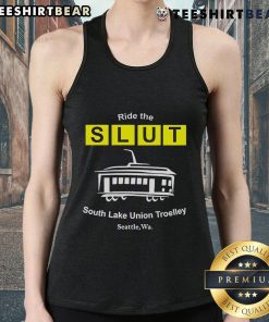 Man wearing a 'Top Ride The SLUT South Lake Union Trolley Seattle WA' tank top, standing by the trolley in Seattle.