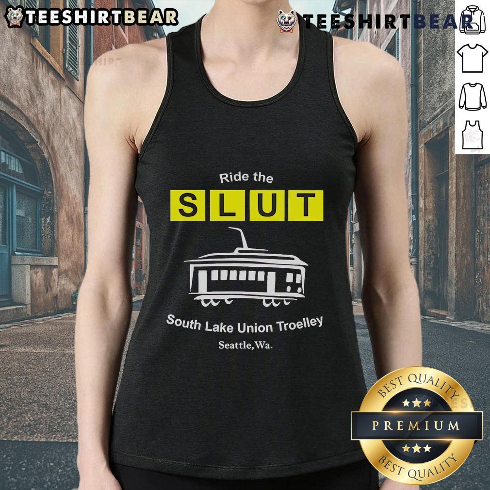 Top Ride The Slut South Lake Union Trolley Seattle Wa Tank Top Man wearing a 'Top Ride The SLUT South Lake Union Trolley Seattle WA' tank top, standing by the trolley in Seattle.