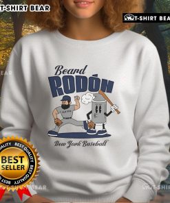 Carlos Rodon in a New York Yankees sweatshirt, showcasing his beard during mid-summer baseball season.