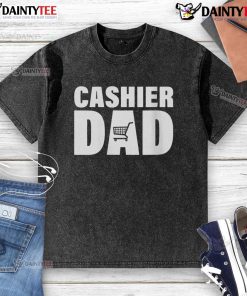 Awesome Cashier Dad wearing a washed T-shirt, smiling while working at the register in a vibrant grocery store.