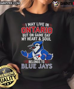 Cozy Toronto Blue Jays sweatshirt featuring 'I May Live In Ontario But On Game Day My Heart Belongs To The Blue Jays' design.