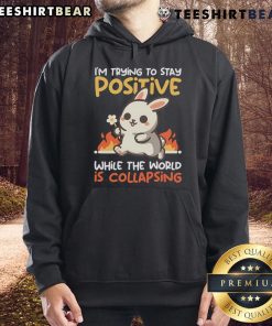 Cute bunny wearing a hoodie with the phrase I'm trying to stay positive while the world is collapsing, perfect for cozy vibes.