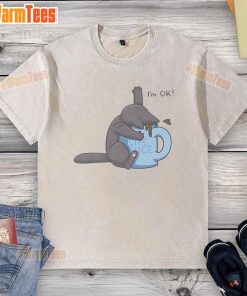 Cute cat playfully sitting in a coffee cup, wearing a 'I'm OK' washed t-shirt, showcasing its adorable personality.