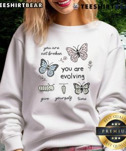 Alt Text: Cute sweatshirt with 'You Are Not Broken, You Are Evolving, Give Yourself Time' slogan, perfect for cozy casual wear.