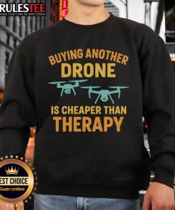 Funny sweatshirt saying 'Buying Another Drone is Cheaper Than Therapy' perfect for drone enthusiasts and humor lovers.