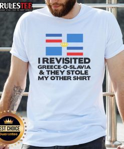 Funny scene in Greece: a traveler humorously pointing at a stolen T-shirt with 'Greece O Slavia' slogan.