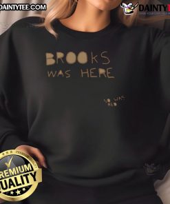 Good Brooks was here in a red sweatshirt, showcasing a stylish urban look at a vibrant city backdrop.