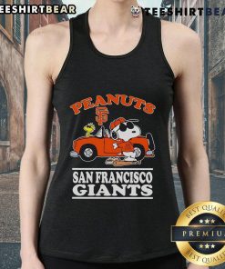 Good San Francisco Giants fan wearing a peanuts tank top poses next to a car, showcasing team spirit and style.
