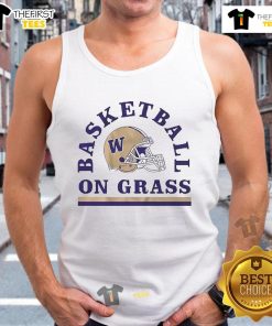 Alt Text: Good Washington Huskies football and basketball helmet on grass next to a tank top, showcasing team spirit.