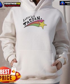 Happy Aaron Lee Tasjan wearing a colorful rainbow star hoodie, showcasing vibrant style and joyful expression.