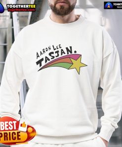 Happy Aaron Lee Tasjan wearing a colorful rainbow star sweatshirt, showcasing his vibrant style and personality.