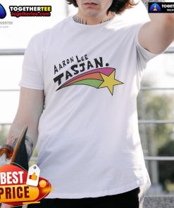 Alt Text: Happy Aaron Lee Tasjan wearing a colorful rainbow star t-shirt, showcasing vibrant design and joyful expression.