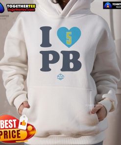 Alt Text: Happy Paige Bueckers wearing a stylish I Love PB Dallas Wings hoodie, showcasing her love for basketball and team spirit.