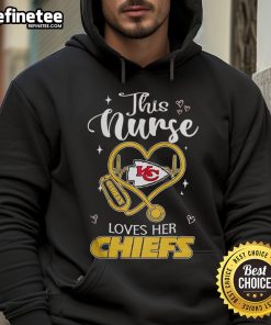 Happy nurse wearing a Kansas City Chiefs hoodie, celebrating her team spirit and dedication in a cheerful setting.