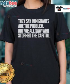 Hot ladies' tee featuring the phrase 'Immigrants are not the problem' and a graphic referencing Capitol storming.