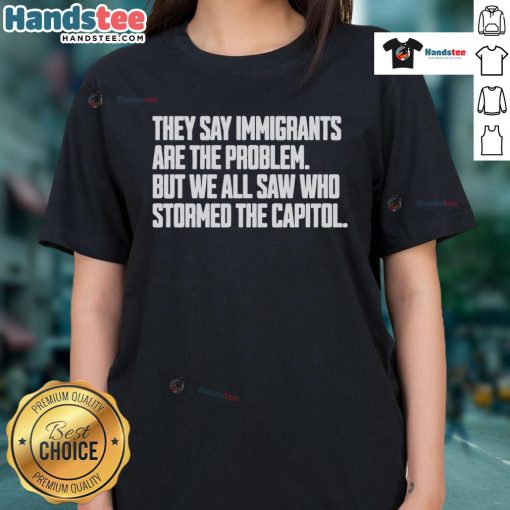 Hot ladies' tee featuring the phrase 'Immigrants are not the problem' and a graphic referencing Capitol storming.