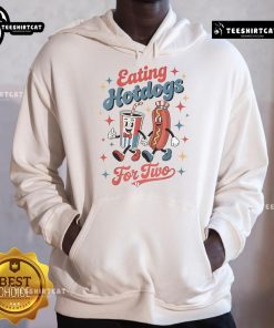 Couple enjoying hotdogs while wearing 'Nice Eating Hotdogs for Two' hoodies, perfect for food lovers and cozy outings.