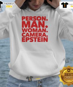 Friendly man and woman wearing Epstein hoodies, posing together with a camera in a vibrant urban setting.