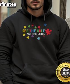 Colorful puzzle piece hoodie promoting autism awareness with the slogan 'See The Able, Not The Label'.
